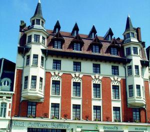 a large red and white building with a roof at Le Vieux Beffroi in Béthune