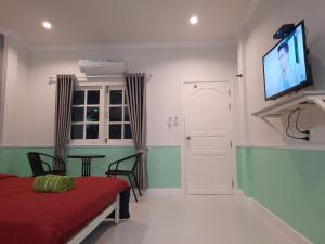 a room with a bed and a flat screen tv at Fancy Carp Resort Hua-Hin in Hua Hin