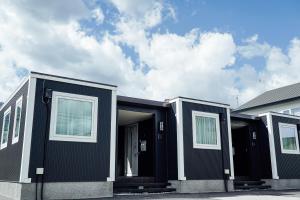 une rangée de maisons modulaires noires avec leurs portes ouvertes dans l'établissement Jstyle STAY Furano, à Furano