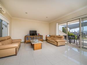 a living room with a couch and a tv and a table at Seafront Unit 50 in Jurien Bay