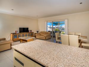 a living room with a kitchen and a living room with a table at Seafront Unit 49 in Jurien Bay