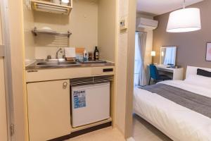 a hotel room with a sink and a bed at Tino Anastasia in Osaka