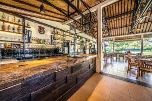 a bar in a restaurant with tables and chairs at Ocean Sun Dive Resort in Tulamben