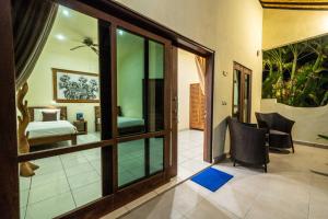 a room with a bedroom and a bed and a room with glass doors at Ocean Sun Dive Resort in Tulamben