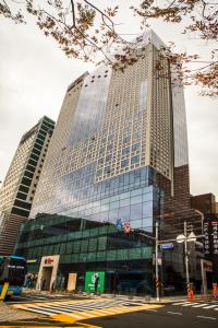 wysoki budynek z oknami wychodzącymi na ulicę miejską w obiekcie Ramada Encore by Wyndham Busan Station w Pusanie