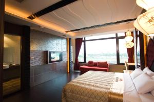 a hotel room with a bed and a large window at Chateau Motel & Spa in Kaohsiung