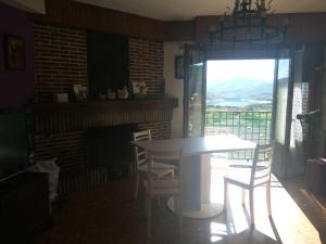 una sala da pranzo con tavolo, sedie e camino di Apartamento Turísticos Luar 3 a El Rasillo