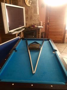a pool table with two bats and a tv at Apartamento Turistico Luar 1 in El Rasillo