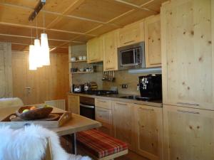 a kitchen with wooden cabinets and a table with a bowl at Chalet - Direkt am 5 Sterne Campingplatz Aufenfeld im Zillertal mit Hallenbad und Sauna in Aschau