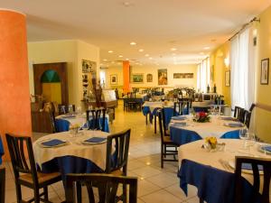 un restaurante con mesas y sillas con manteles azules en Mini Hotel, en Asti