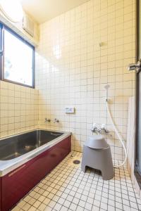 a bathroom with a tub and a toilet and a sink at Classic Japan Living ASAMA in Fujikawaguchiko