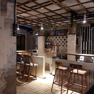 bar z krzesłami i blatem w kuchni w obiekcie The Flying Fish Hostel Cebu w Cebu
