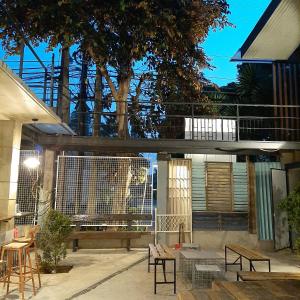 a patio with benches and tables and a bridge at The Flying Fish Hostel Cebu in Cebu City