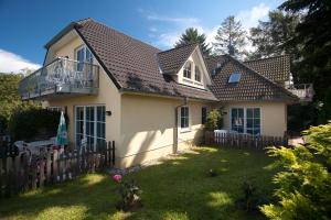 een wit huis met een hek en een tuin bij Haus Seeblick-Binz in Binz