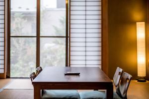 a table and chairs in a room with a window at Classic Japan Living ASAMA in Fujikawaguchiko