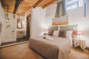 una camera con un grande letto e un bagno di Residenza Storica le Civette a Castel del Monte
