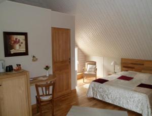 1 dormitorio con cama, escritorio y silla en La Clé des Chants en Tauxigny