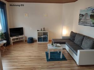 a living room with a couch and a tv at Ferienwohnung Langenselbold in Langenselbold