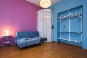Zimmer mit einem blauen Stuhl und lila Wänden in der Unterkunft Итальянские комнаты Пио на канале Грибоедова 35 in Sankt Petersburg