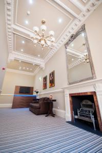 sala de estar con chimenea y espejo en Palmerston Suites, en Edimburgo
