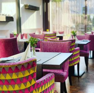 a row of tables and chairs in a restaurant at Hotel Ambiente in Bückeburg