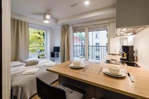 a kitchen with a table in a room with a bed at Thomas' Home - Trendy, Central & Balcony in Tallinn