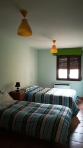 2 łóżka w pokoju z zielonymi ścianami w obiekcie Apartamento Martín w mieście Mora de Rubielos