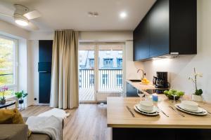 a kitchen and living room with a table with dishes on it at Thomas' Home - Trendy, Central & Balcony in Tallinn