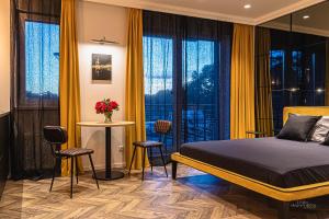 - une chambre avec des rideaux jaunes, un lit, une table et des chaises dans l'établissement No.1 Apartment Link-To-Happiness, à Klaipėda