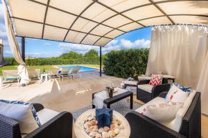 a patio with furniture and a swimming pool at Finca Llum in Manacor