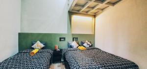 a room with two beds and a mirror at MADOR Malang Dorm Hostel in Malang