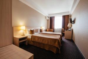 クルスクにあるAvrora Business Hotelのベッド2台と窓が備わるホテルルームです。