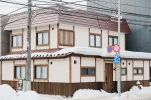 a house with snow on the roof at Lampstand STAY Sapporo-House A in Sapporo