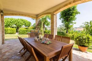 a wooden table and chairs on a patio at Villa Azzurra in Mondavio