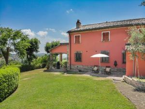 Mondavio的住宿－Villa Azzurra，享有带庭院的房屋外部景致