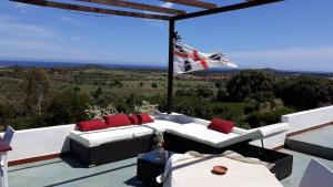 d'une terrasse avec un canapé blanc et des oreillers rouges. dans l'établissement Villa delle torri, à Pula
