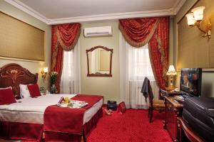 een hotelkamer met een bed en een televisie bij Staro Hotel in Kiev