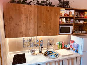 encimera de cocina con fregadero y microondas en Adriana casa vacanze mare Etna Sicilia, en Acireale