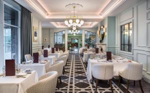 ein Restaurant mit weißen Tischen und Stühlen und einem Kronleuchter in der Unterkunft The Heritage in Killenard