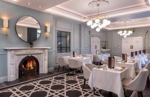 a dining room with tables and chairs and a fireplace at The Heritage in Killenard