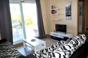 a living room with a couch and a tv at Brisas C8, ático, 3 dormitorios, playa a 50m, by Bookindenia in Denia