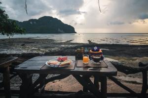 una mesa de picnic con comida y bebida en la playa en Phi Phi Sunset Bay Resort, en Islas Phi Phi