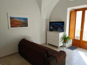 een woonkamer met een bank en een televisie bij ...a casa di Sandro in Tricarico