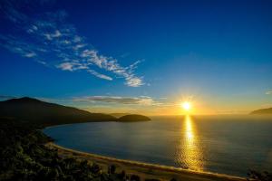a view of a beach with the sun in the sky at Pearl Sea Hotel in Danang