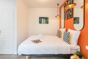 Cette chambre comprend un lit avec un mur orange. dans l'établissement Apartments WS Marais - Musée Pompidou, à Paris