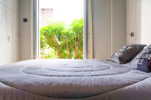 uma cama grande num quarto com uma janela grande em The Burton Luxury 1BR in Plaka, Athens em Atenas