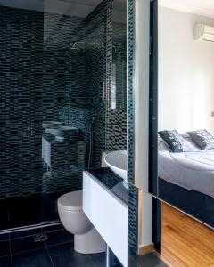 uma casa de banho com uma cama, um WC e um lavatório. em The Burton Luxury 1BR in Plaka, Athens em Atenas