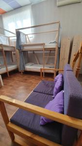 a room with three bunk beds and purple pillows at Goodzone Hostel in Volgograd