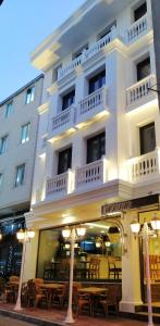 MORAVA HOTEL في إسطنبول: مبنى أبيض طاولات أمامه