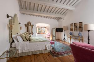 1 dormitorio con 1 cama, mesa y sillas en Castello Di Meleto en Gaiole in Chianti